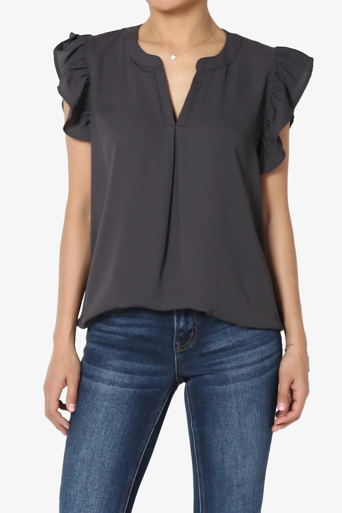 A woman wearing a ruffle blouse with jeans