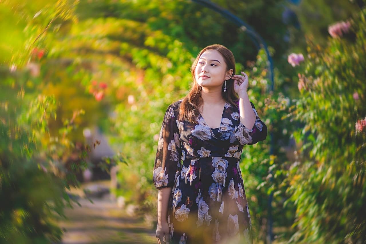 A plus-size woman strolling in a garden